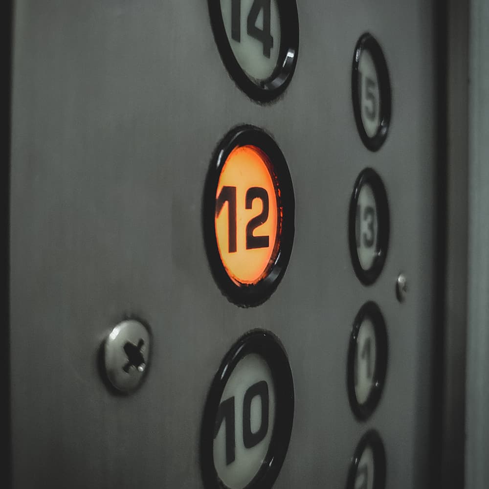 An elevator button with the number twelve illuminated